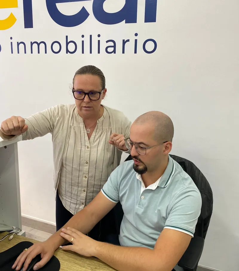 Carolina Sánchez López y un compañero de Wereal analizando el informe de una propiedad